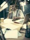 Portrait of a bearded businessman who is checking details of his upcoming meeting in his notebook and typing. Royalty Free Stock Photo