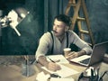 Portrait of a bearded businessman who is checking details of his upcoming meeting in his notebook and typing. Royalty Free Stock Photo