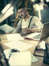 Portrait of a bearded businessman who is checking details of his upcoming meeting in his notebook and typing. Royalty Free Stock Photo