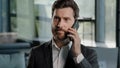 Portrait bearded Caucasian middle-aged adult business man talking phone at office negotiate virtual sales conversation Royalty Free Stock Photo