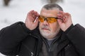 Portrait of bearded Caucasian senior man adjusting sun glasses at winter season