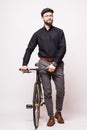 Portrait of a bearded handsome young man walking with fixie monospeed bicycle over white background