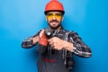 Portrait of bearded handyman with electric drill isolated on blue background Royalty Free Stock Photo