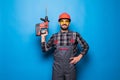 Portrait of bearded handyman with electric drill isolated on blue background Royalty Free Stock Photo