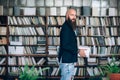 Portrait of bearded hipster man iwith books n library