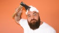 Portrait of bearded hipster man shaving his head with an ax axe, hatchet looking to the camera Royalty Free Stock Photo