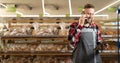 Portrait of bearded man calling supplier while selling fresh bread and grocery at supermarket, banner Royalty Free Stock Photo