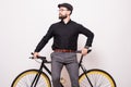 Portrait of a bearded man leaning on fixie bicycle over white background