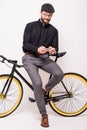Portrait of a bearded man leaning on fixie bicycle play games on the mobile phone over white background