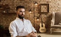 Portrait of bearded man at loft home with guitar