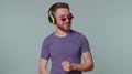 Cheerful attractive man listening music via headphones and dancing disco fooling around having fun Royalty Free Stock Photo