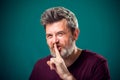 A portrait of bearded man showing hush gesture. People and emotions concept Royalty Free Stock Photo