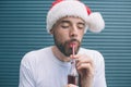 Portrait of bearded man standing and drinking coke through plastic straw. He is keeping eyes closed and enjoying the Royalty Free Stock Photo