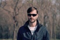 Portrait of a bearded man wearing sunglasses in a park. Royalty Free Stock Photo