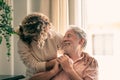 Portrait of bearded senior man looking at his middle-aged daughter, spending time together at home Royalty Free Stock Photo