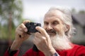 Portrait of bearded senior man photographer with old camera taking photo Royalty Free Stock Photo