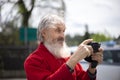 Portrait of bearded senior man photographer with old camera taking photo Royalty Free Stock Photo