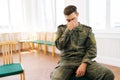 Portrait of bearded young Caucasian soldier in camouflage uniform with PTSD crying sitting in circle during group Royalty Free Stock Photo