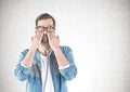 Casual man covering eyes with hands, concrete