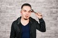 Portrait of bearded young man holding adjustable wrench on brick wall background Royalty Free Stock Photo