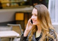 Portrait of beatiful young woman speaking on smartphone outdoors