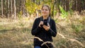 Portrait of beautfiul young woman with digital camera walking in wild forest