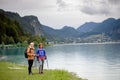 Active elderly couple hiking together in spring mountains. Senior tourists embracing each other in front of lake. Royalty Free Stock Photo