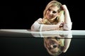 Portrait of a beautiful actress near a white piano.