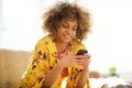 Beautiful african american woman using cellphone at home Royalty Free Stock Photo