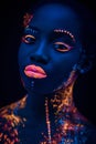 Portrait of beautiful african fashion model in neon UF light Royalty Free Stock Photo