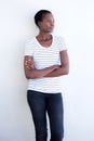 Beautiful afro american woman standing with arms crossed against white wall and looking away Royalty Free Stock Photo