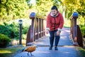 Portrait of beautiful aged woman in the park. Pay with bird. Feed duck Royalty Free Stock Photo