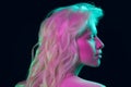 Portrait of beautiful albino girl on dark studio background in neon light