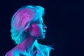 Portrait of beautiful albino girl on dark studio background in neon light