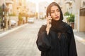 Portrait of beautiful Arab businesswoman wearing hijab talking on cell phone on the city street Royalty Free Stock Photo