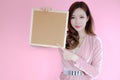 Portrait beautiful asia woman on pink background and wearing pink clothes with holding cork board, emotions action, fashion set Royalty Free Stock Photo