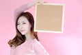 Portrait beautiful asia woman on pink background and wearing pink clothes with holding cork board, emotions action, fashion set Royalty Free Stock Photo