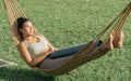 Portrait Beautiful Asian adult sportive woman wearing sport bra, resting, taking nap or sleeping on a cradle with calm in outdoor