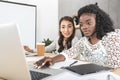 portrait of beautiful asian and african american businesswomen working on laptop together Royalty Free Stock Photo