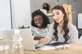 portrait of beautiful asian and african american businesswomen working on laptop together Royalty Free Stock Photo