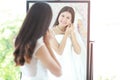 Portrait of beautiful Asian bride put on earring looking in mirror, her back out of focus large copy space, horizontal layout and