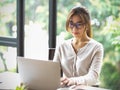 Portrait of beautiful asian businesswoman with eyeglasses working on laptop