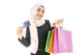 Portrait of beautiful asian muslim woman in a black hijab smiling cheerful with shopping bag and credit card  isolated over white Royalty Free Stock Photo