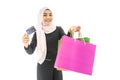 Portrait of beautiful asian muslim woman in a black hijab smiling cheerful with shopping bag and credit card  isolated over white Royalty Free Stock Photo