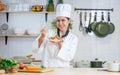 Portrait beautiful Asian professional female chef wearing white uniform, hat, showing plate of spaghetti, cooking in kitchen, Royalty Free Stock Photo