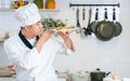 Portrait beautiful Asian professional male chef wearing white uniform, hat, holding, showing plate of spaghetti, cooking in Royalty Free Stock Photo