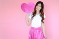 Portrait beautiful asian teen girl wearing white T-shirt and pink skirt on pink background, happy valentine day concept, model hol Royalty Free Stock Photo