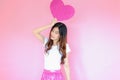 Portrait beautiful asian teen girl wearing white T-shirt and pink skirt on pink background, happy valentine day concept, model hol Royalty Free Stock Photo