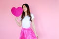 Portrait beautiful asian teen girl wearing white T-shirt and pink skirt on pink background, happy valentine day concept, model hol Royalty Free Stock Photo