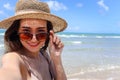 Portrait of beautiful Asian woman with big hat and sunglasses enjoy spending time on tropical sand beach blue sea, happy smiling Royalty Free Stock Photo